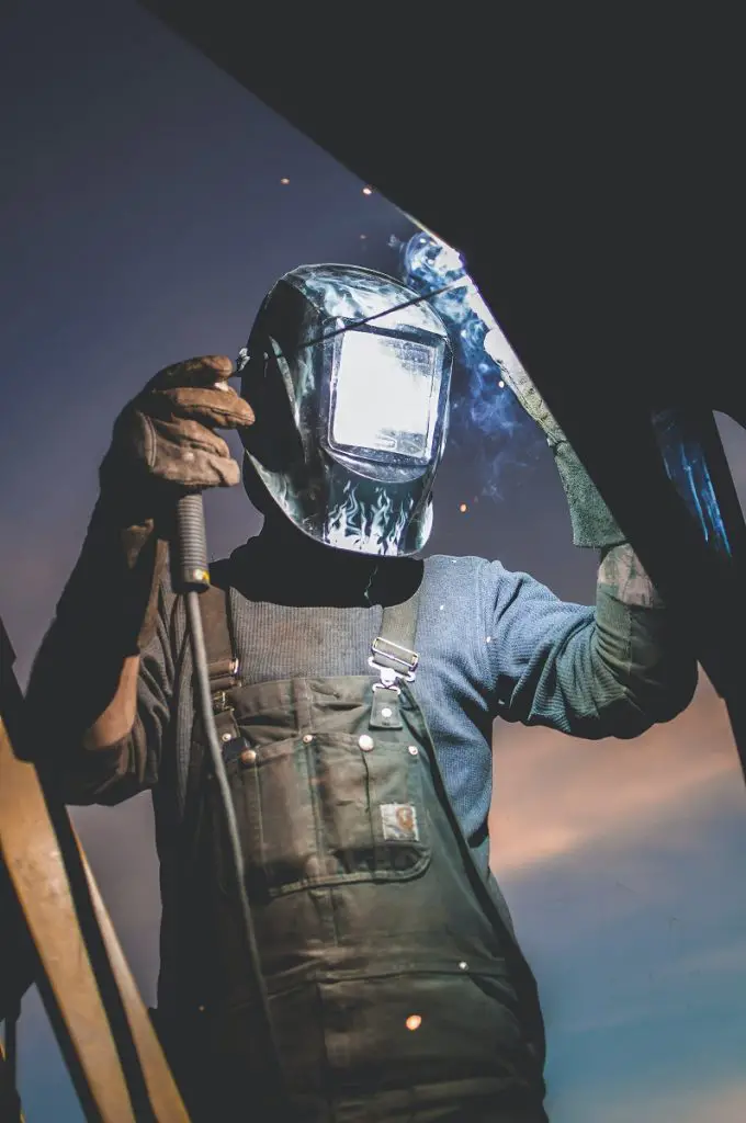 Welding wearing protective equipment